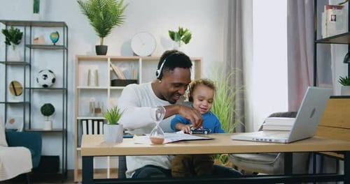 Man Working at Home with Child Playing