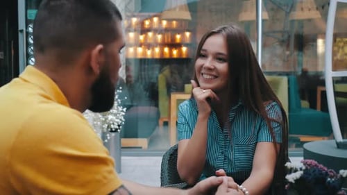 Close-up View of Beautiful Smiling Young Girl Sitting at Table and Talking Outdoor of Trendy Cafe