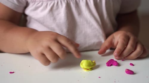 Child Plays With Modeling Clay At Table
