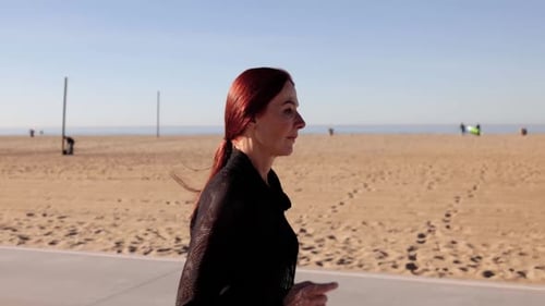 Woman Jogging Along Sunny Beach Boardwalk for Fitness
