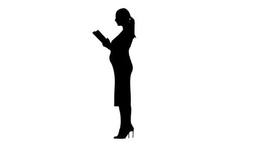 Pregnant Woman Is Reading a Book. Silhouette. White Background. Slow Motion