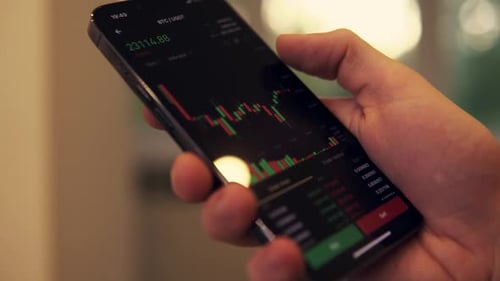 Hand Using Mobile App to Look at Stock Chart