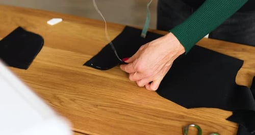 Mature Adult Hand Sewing Black Fabric