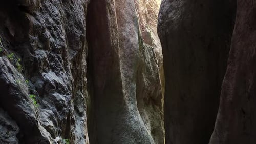 Déplacement de la caméra dans l'étroit canyon d'une gorge de montagne, illuminé par le soleil