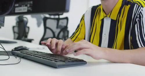 Businessman Working at His Desktop Computer Sitting at His Desk in the Open Space Startup Office