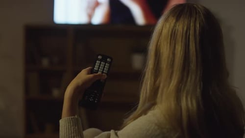 Woman with Remote Control Changing TV Channels