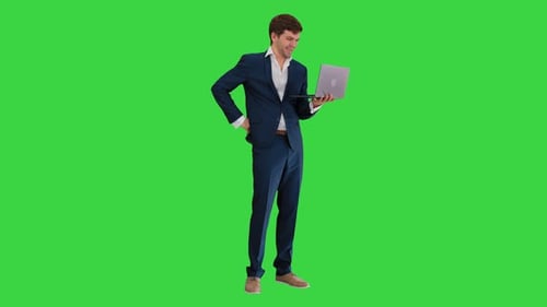 Jeune homme d'affaires souriant utilisant un ordinateur portable debout sur écran vert Chroma Key