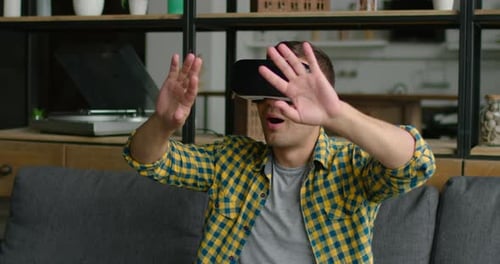 Man Uses Virtual Reality Headset on Couch