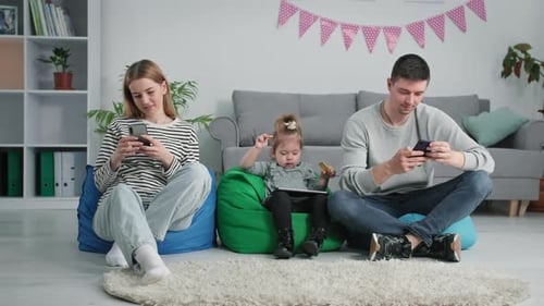 Modern Technologies Young Family with a Small Child Uses Gadgets to View Social Networks While