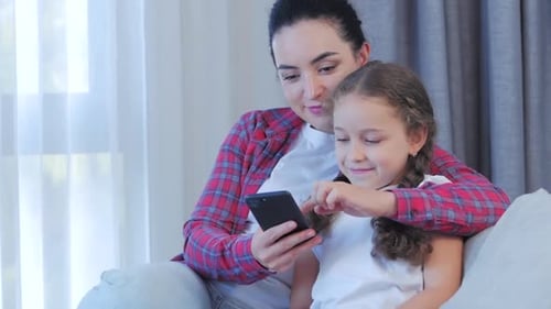 Woman and Child Using a Phone Together Indoors