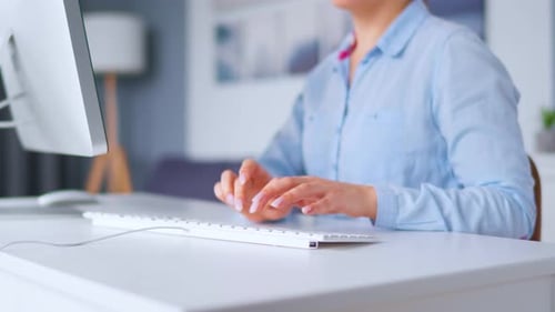 Woman Typing on White Keyboard in Bright Office