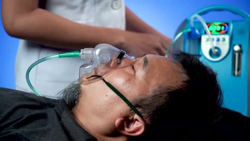 Un homme asiatique porte un masque à oxygène en raison de difficultés respiratoires et une infirmière pour l'aider à s'occuper