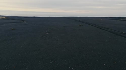 Drone Over Markers In Black Sand Landscape