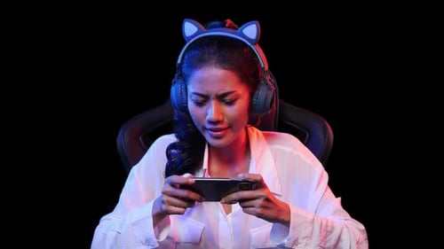 Woman Playing Game on Smartphone with Cat Ear Headphones