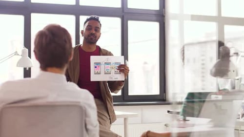 Man Presents App Design to Coworkers in Office