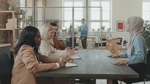 Woman Interviewed by Panel in Modern Office Space