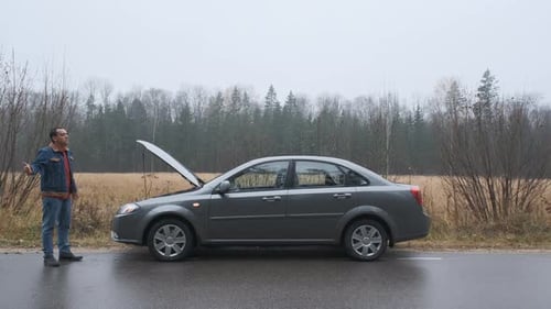 Man Driver Catching Help for Her Broken Car, Accident at Empty Country Road