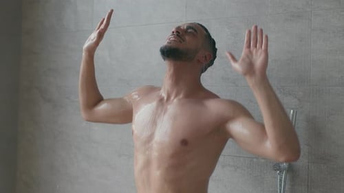 Young Man Enjoys Washing in Modern Tiled Shower