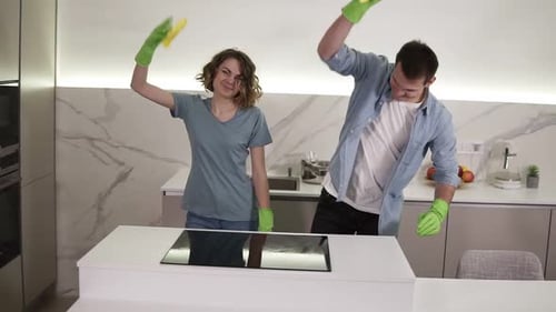 Couple Cleaning and Dancing in Modern Kitchen