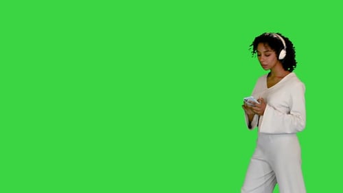 Young Black Lady in White Grooving To Music on a Green Screen Chroma Key