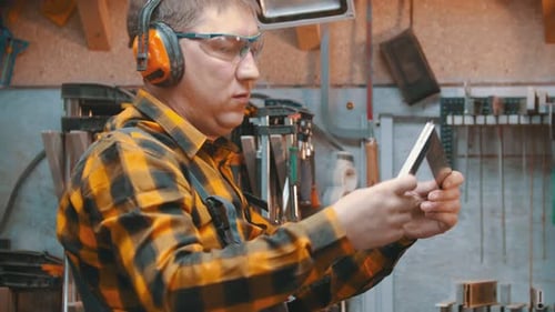 Man Inspecting Metal In Woodworking Shop