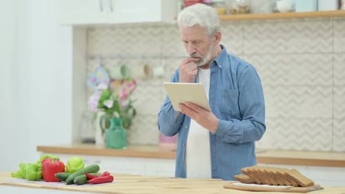 Mature Man Using Tablet in Bright Kitchen
