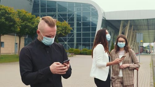 People with Masks Using Smartphones in Urban Setting