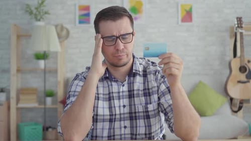 Man Holding Credit Card Frustrated with Online Payments