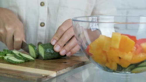 Cut cucumber for salad.