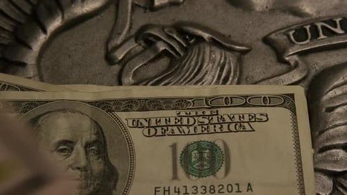 Rotierende Aufnahmen amerikanischer Papierwährung auf einem amerikanischen Adlerschild-Hintergrund