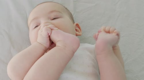 Baby Holds and Chews on Foot