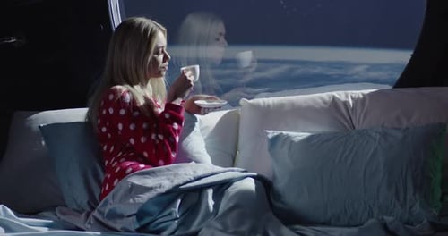 Femme appréciant la vue et un café dans un vaisseau spatial