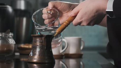 Person Prepares Turkish Coffee in Traditional Copper Pot