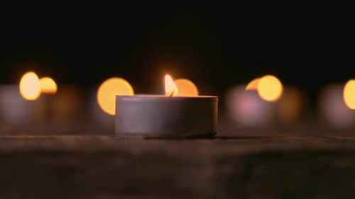 Burning Tea Candles Giving Warm Light in Dark
