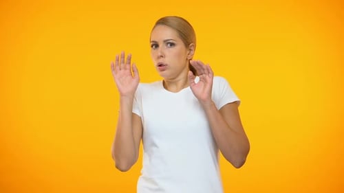Scared Woman Raises Hands in Defense on Orange