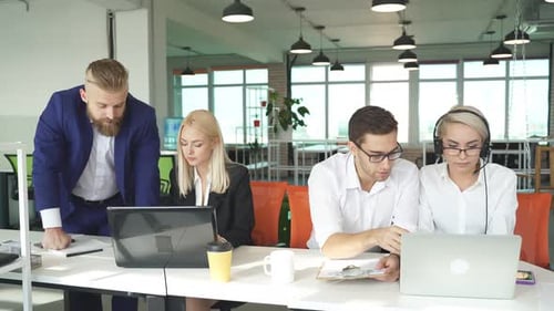 Professionals Collaborating on Laptop in Modern Office