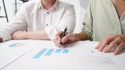 Adults Collaborate on Charts at a Table