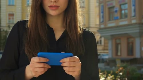 Woman Uses Smartphone in Urban Outdoor Setting