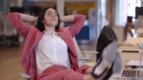 Beautiful businesswoman relaxing in office with feet up