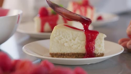 Cheesecake Being Drizzled with Red Sauce