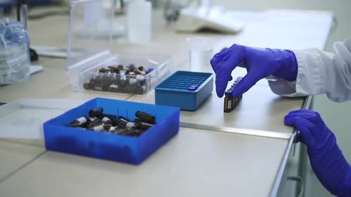 Lab Worker Places Vials on Workbench