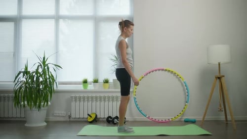 Woman Does Lunges with Dumbbells Indoors