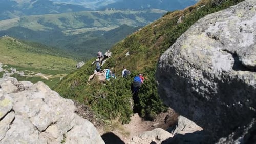 Gruppe von Touristen und Kindern mit Rucksäcken geht auf Stone Trail in Mountain