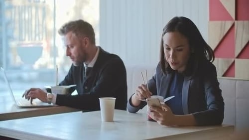 Man and Woman Eating Lunch at Tables