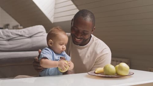 Father and Baby with Apples at Home