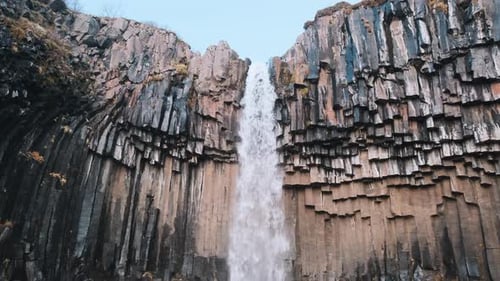 Low angle view looking up at majestic Svartifoss Waterfall, Iceland. Static.