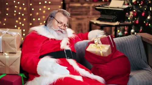 Sleeping Male Santa Claus Lying on Couch Tiredness at Christmas Eve