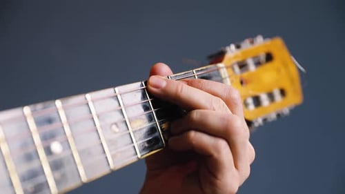 Hombre toca la guitarra acústica en Blue Wall Closeup