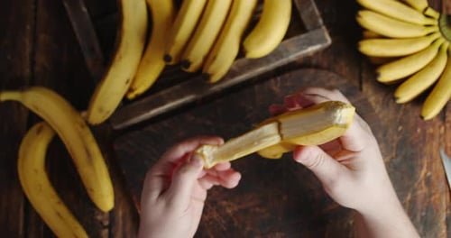 Peeling a Banana on Wooden Cutting Board