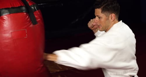 Man Punches Heavy Bag in Gym Workout
